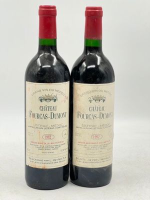 deux bouteilles de vin rouge posées l'une à côté de l'autre sur une surface blanche