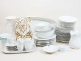 a lot of white plates and cups on the table