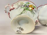 two cups and saucers with flowers painted on them