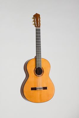une guitare acoustique accrochée à un mur sur fond blanc