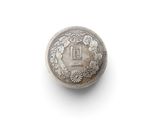 an old silver coin sitting on top of a white surface