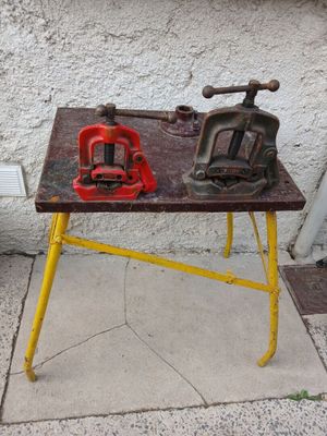 two vises on a workbench on the sidewalk