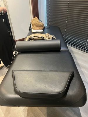 une femme debout à côté d'une table de massage recouverte d'une serviette
