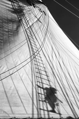 photographie en noir et blanc d'un homme debout sur une voile
