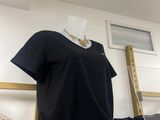 a black t - shirt sitting on a shelf next to a ladder