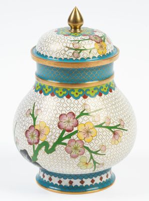 une image représentant un vase blanc orné d'un couvercle bleu et de fleurs