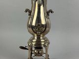 an antique silver coffee urn on a stand on a white background