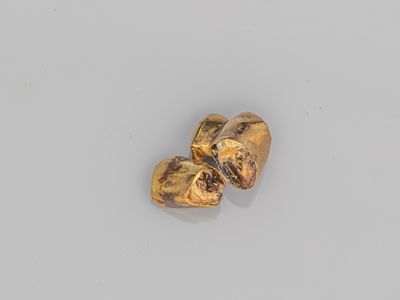 une paire de boucles d'oreilles en or en forme de cœur posées sur un fond blanc
