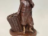 a statue of a woman with a basket on a white surface
