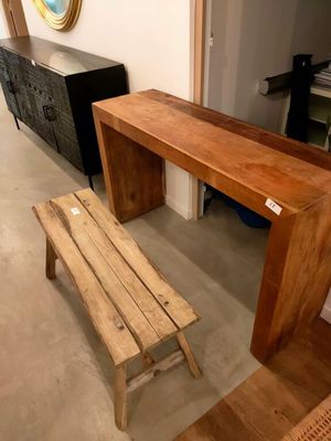 un banc en bois placé à côté d'une table en bois dans une pièce