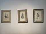 three framed pictures on the wall of a room