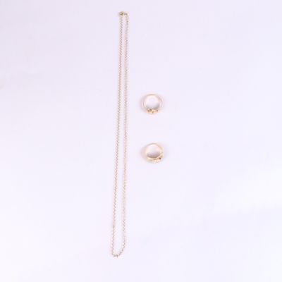 une paire de boucles d'oreilles en perles et un collier en or sur fond blanc