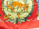 a red banner with a picture of deer and birds on it