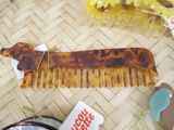 a dog shaped comb sitting on top of a table next to other items