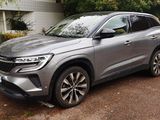 the silver suv is parked in the parking lot near a building