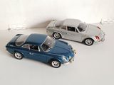 two toy cars sitting next to each other on a white surface