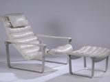 a white leather chair and ottoman in a white room