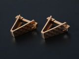 pair of gold triangle stud earrings on a black surface