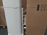 un réfrigérateur blanc posé à côté d'une pile de cartons
