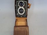 a brown leather case with a camera inside of it