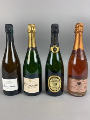 quatre bouteilles de vin sont alignées sur une table