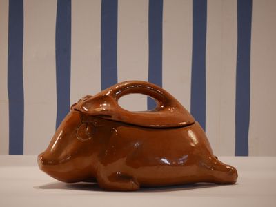 a brown bag sitting on a table with a striped wall behind it