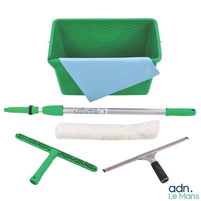 un gros plan sur un seau vert contenant une serpillière, une brosse et un chiffon de nettoyage
