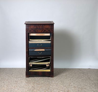 a small wooden cabinet with a lot of files on it