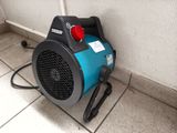 a small blower sitting on the floor next to a wall