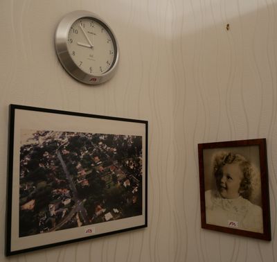 une horloge accrochée au mur au-dessus d'un portrait de femme