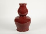 a red vase that is sitting on a white surface
