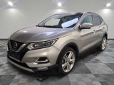 un SUV Nissan argenté garé sur un sol en carrelage à damier