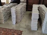 many stacks of books stacked on top of each other in a room