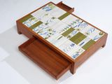 a small wooden table with a tile top on it