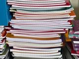 une pile de papiers posée sur un bureau, à côté d'une chaise