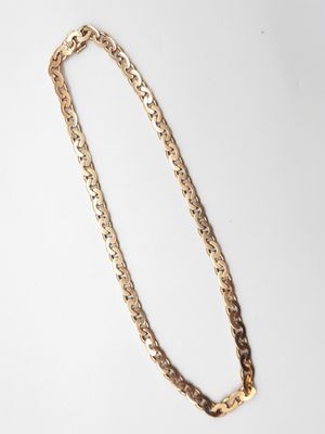 un collier à chaîne en or sur fond blanc