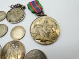 beaucoup de pièces et une médaille posées sur une table