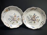 deux assiettes ornées de fleurs et d'oiseaux, posées sur une table