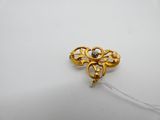 an image of a gold and diamond broochle on a white surface