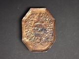 a small gold plate with a picture of a man on it
