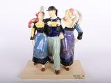 une figurine représentant trois personnes debout côte à côte