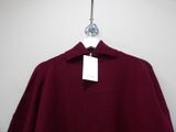 a close up of a maroon shirt hanging on a hanger
