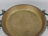 a metal bowl with a handle on a white surface