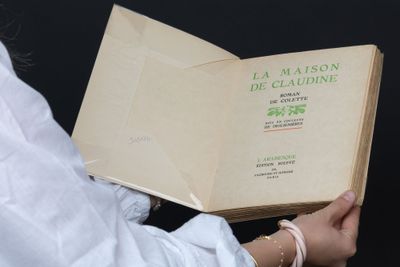 une personne tient un livre entre ses mains, sur fond noir