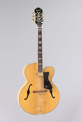 un gros plan d'une guitare posée sur un support, sur fond blanc