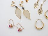 several pairs of earrings and rings are arranged on a white surface