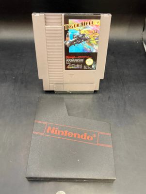a nintendo game sitting on a table next to a book