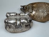 two silver objects sitting on a table next to each other