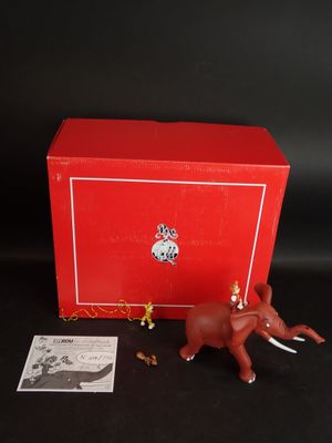 une figurine d'éléphant dans une boîte rouge, à côté d'une carte