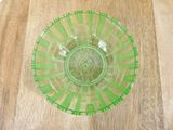 a green glass bowl sitting on a wooden table